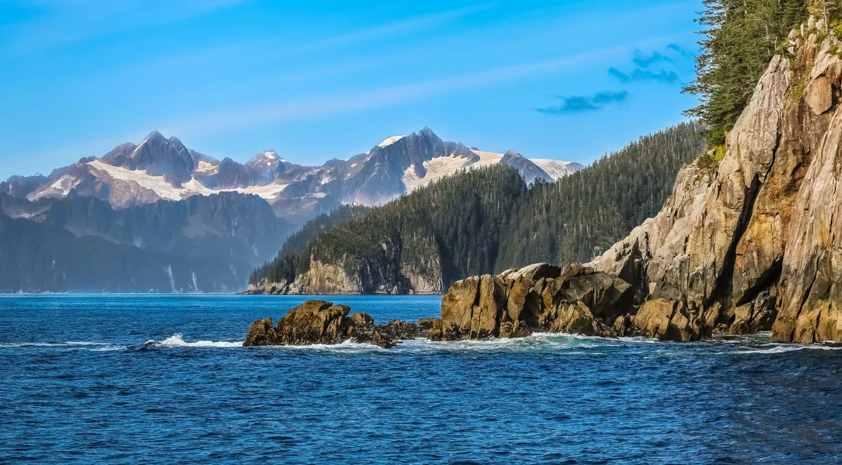 Rocky coastline and snow-capped mountains across Resurrection Bay